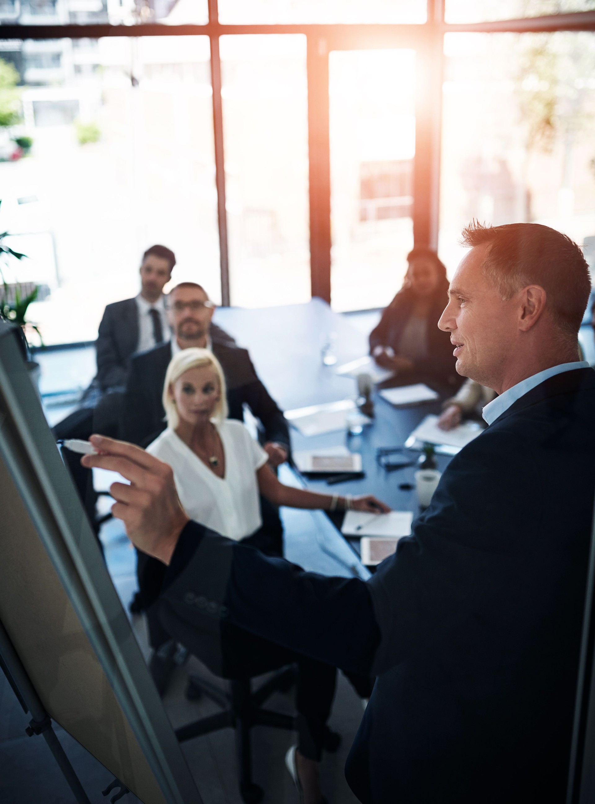 Business people, presentation and man with brainstorming, coaching and feedback with proposal. Group, employees and mentor with information, meeting and planning with vision for company and teamwork